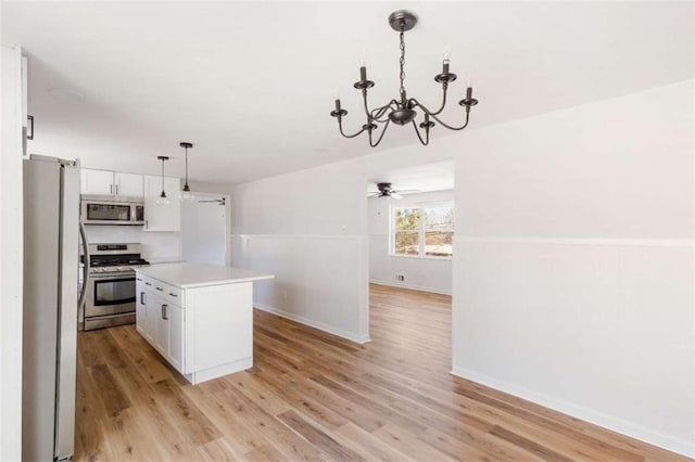 kitchen featuring hanging light fixtures, a center island, white cabinetry, and stainless steel appliances