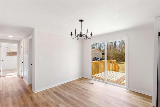 unfurnished dining area with light hardwood / wood-style flooring and a chandelier