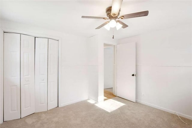 unfurnished bedroom featuring light carpet, a closet, and ceiling fan