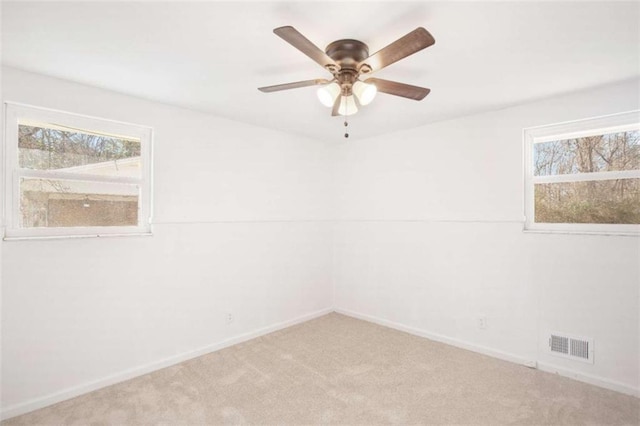 carpeted spare room featuring ceiling fan