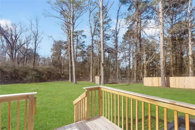 wooden terrace featuring a storage shed and a lawn