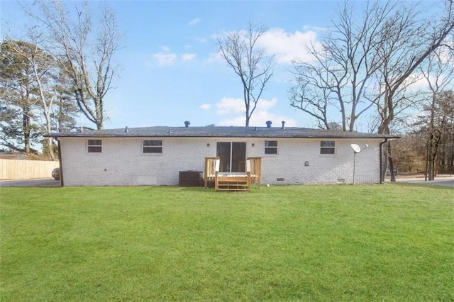 rear view of house with cooling unit and a lawn