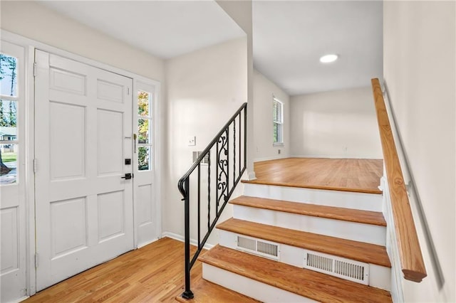 entrance foyer featuring visible vents, recessed lighting, stairs, and wood finished floors