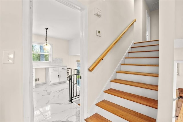 staircase featuring visible vents and marble finish floor