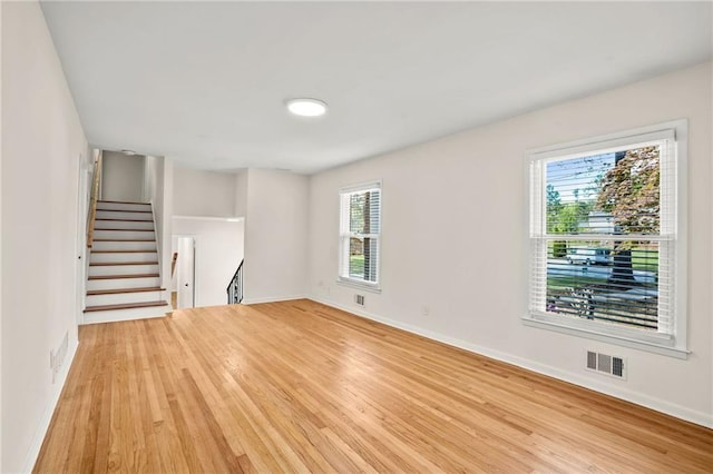 unfurnished living room featuring visible vents, baseboards, and light wood-style floors