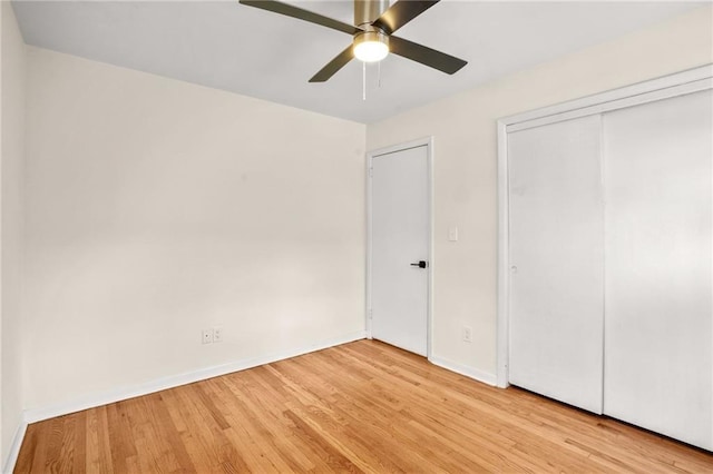 unfurnished bedroom with a ceiling fan, baseboards, light wood-type flooring, and a closet