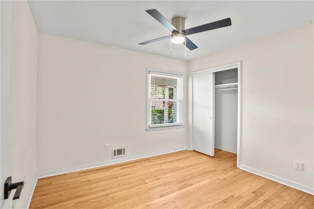 unfurnished bedroom featuring light wood finished floors, visible vents, ceiling fan, baseboards, and a closet