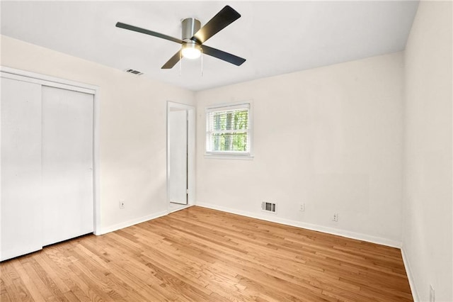 unfurnished bedroom featuring visible vents, baseboards, a closet, and light wood finished floors