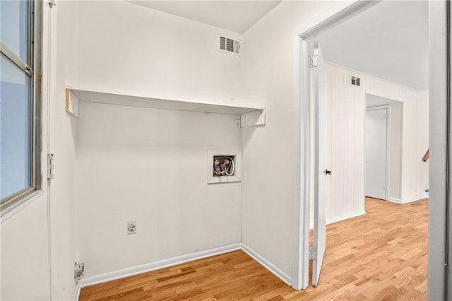 laundry room with electric dryer hookup, visible vents, wood finished floors, and laundry area