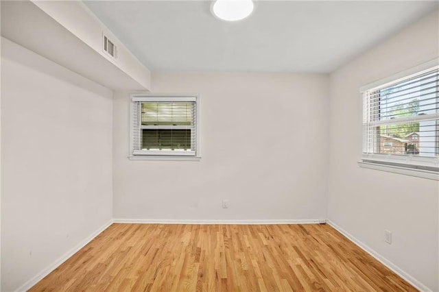 unfurnished room with visible vents, baseboards, and light wood-style floors