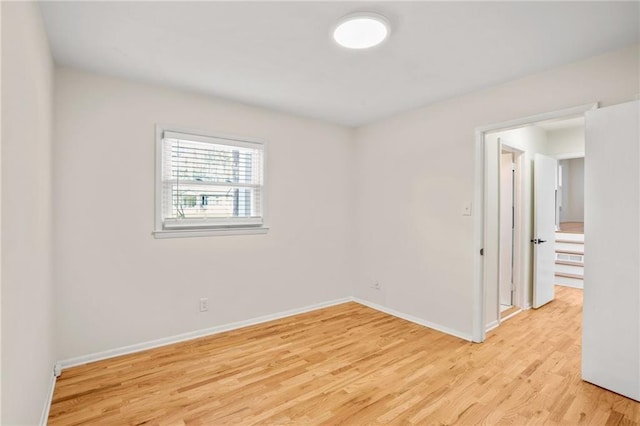 spare room with light wood-style flooring and baseboards