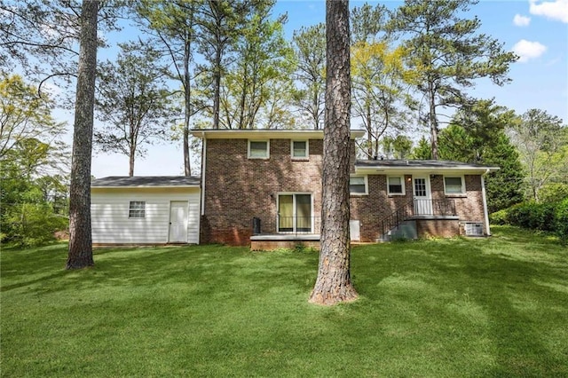 back of property featuring brick siding and a lawn