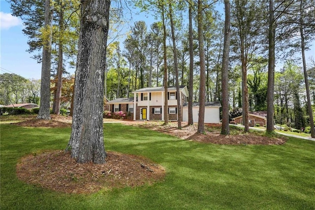 view of front facade with brick siding and a front yard