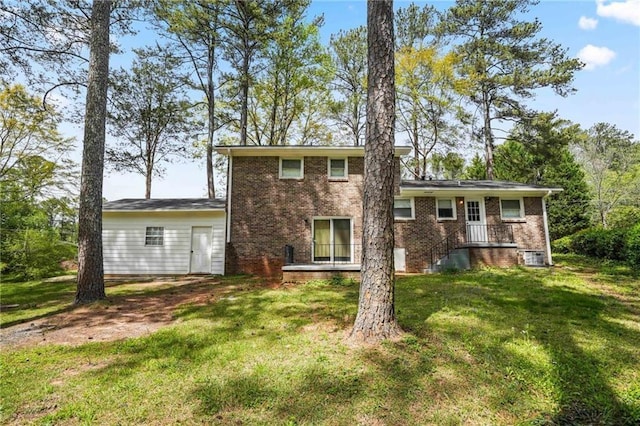 rear view of house with a lawn and brick siding