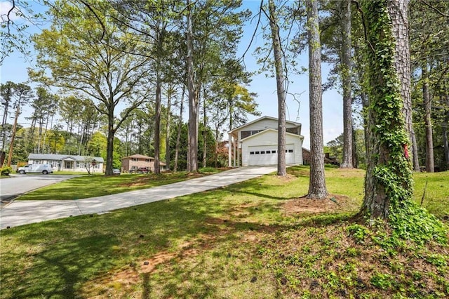 view of front facade with a garage, concrete driveway, and a front yard