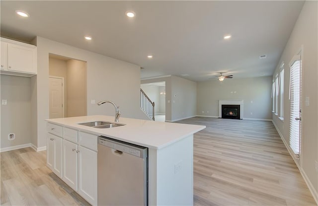 138 Crabbswood Dr, Mcdonough, GA 30253 - kitchen with white cabinets, ceiling fan, a lit fireplace, a sink, and stainless steel dishwasher