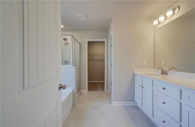 138 Crabbswood Dr, Mcdonough, GA 30253 - bathroom featuring a stall shower, vanity, a spacious closet, tile patterned flooring, and baseboards