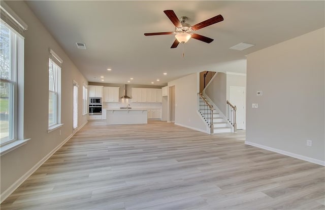 138 Crabbswood Dr, Mcdonough, GA 30253 - unfurnished living room featuring a ceiling fan, baseboards, stairs, and visible vents