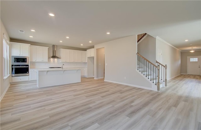 138 Crabbswood Dr, Mcdonough, GA 30253 - kitchen featuring open floor plan, light countertops, white cabinets, appliances with stainless steel finishes, and wall chimney exhaust hood
