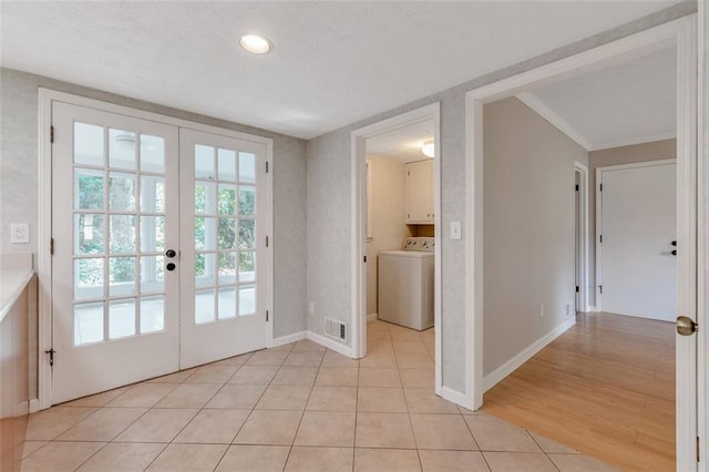 doorway to outside with washer / dryer, ornamental molding, french doors, and light hardwood / wood-style floors