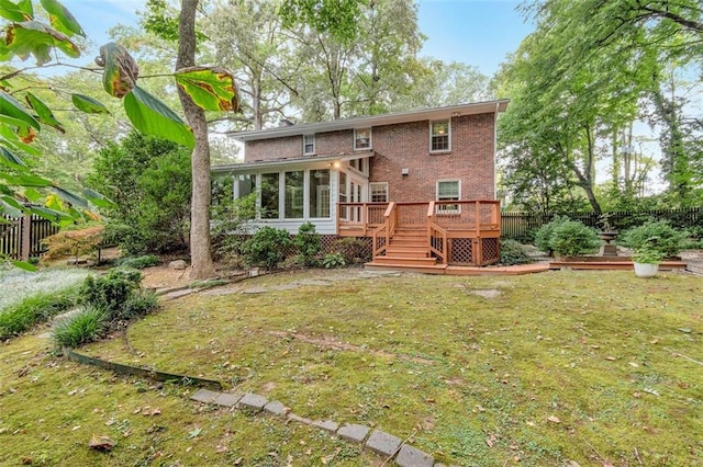 back of house featuring a wooden deck and a yard