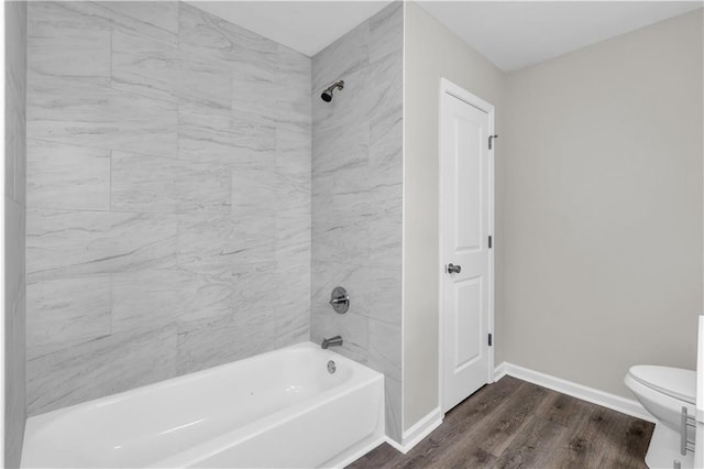 bathroom featuring shower / tub combination, wood finished floors, toilet, and baseboards