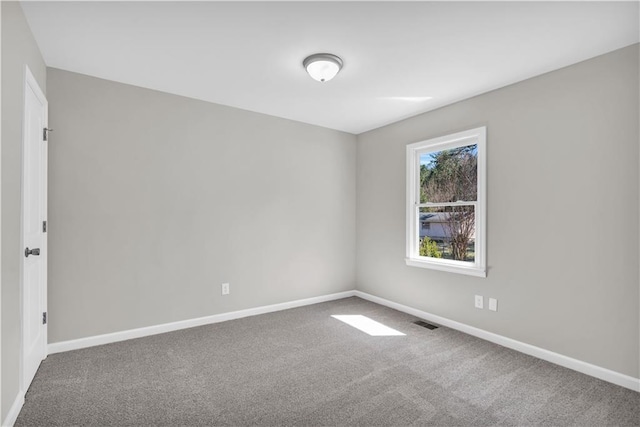 carpeted spare room with visible vents and baseboards