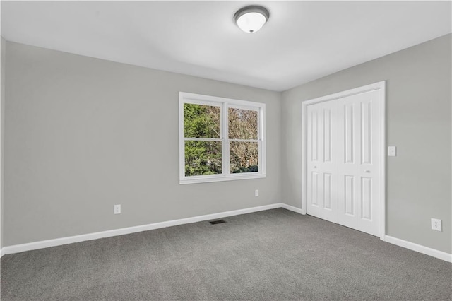 unfurnished bedroom featuring a closet, carpet, visible vents, and baseboards