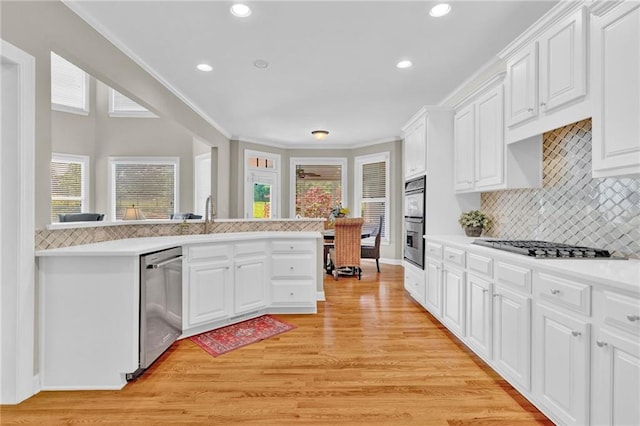 kitchen featuring tasteful backsplash, light countertops, stainless steel appliances, recessed lighting, and light wood-type flooring