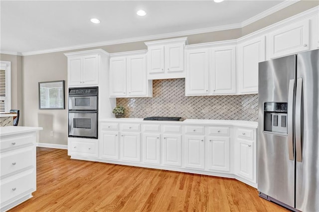 kitchen featuring crown molding, light countertops, light wood finished floors, and stainless steel appliances