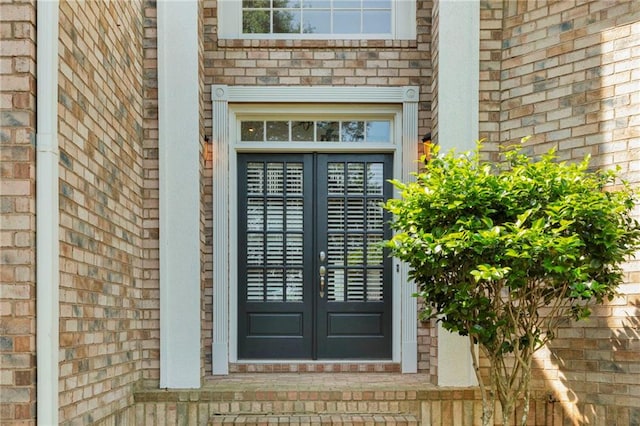 entrance to property featuring brick siding