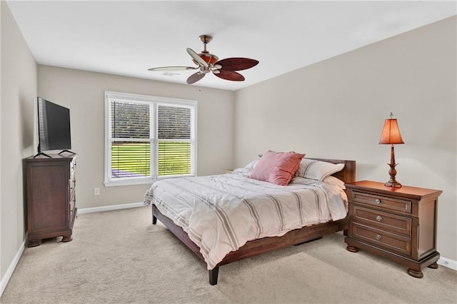 bedroom featuring baseboards, light colored carpet, and ceiling fan