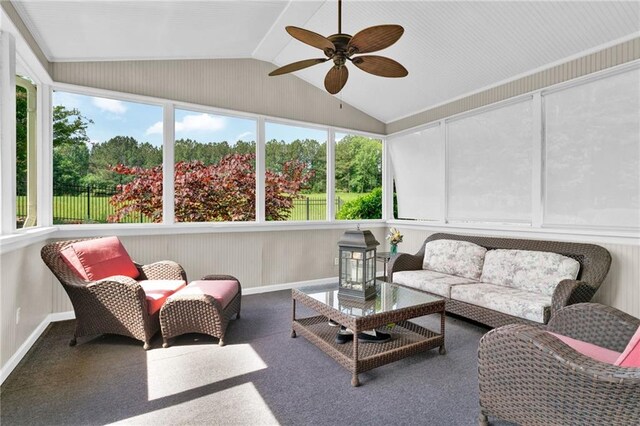 sunroom / solarium featuring a ceiling fan, baseboards, vaulted ceiling, and an outdoor hangout area