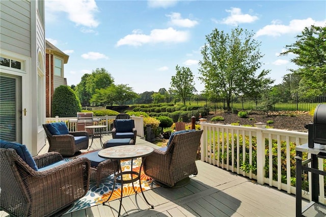 wooden terrace with fence and an outdoor living space