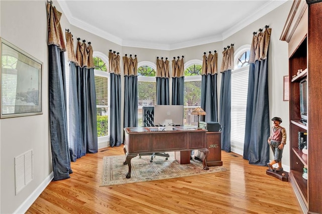 office featuring baseboards, ornamental molding, light wood finished floors, and visible vents