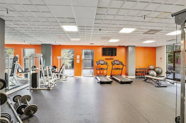 workout area with a drop ceiling and a healthy amount of sunlight