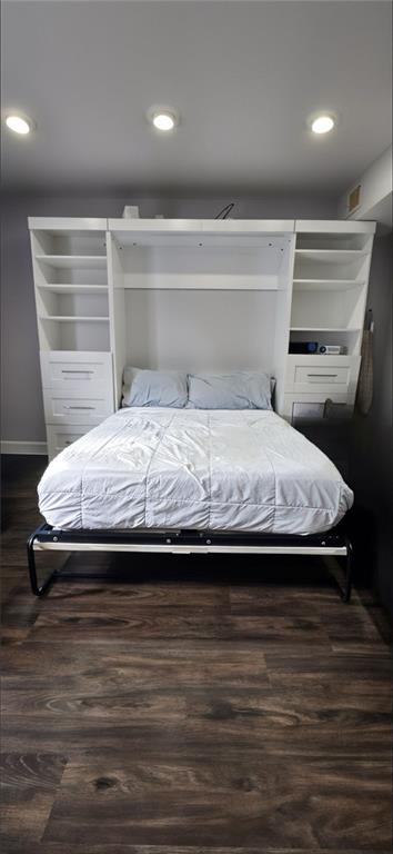 bedroom with dark hardwood / wood-style flooring