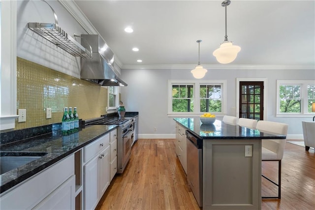 1066 High Point Dr, Atlanta, GA 30306 - kitchen featuring range hood, stainless steel appliances, a kitchen breakfast bar, decorative backsplash, and ornamental molding