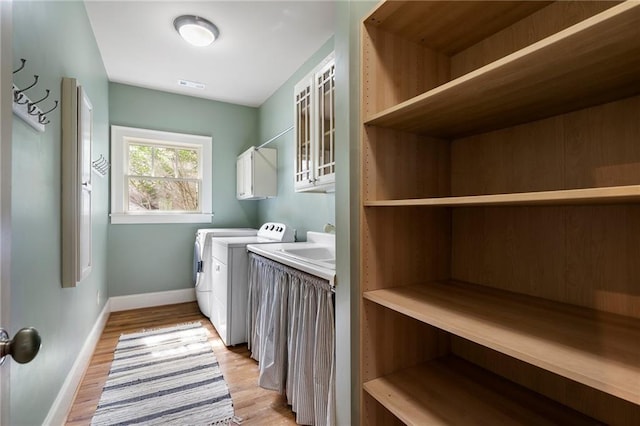 1066 High Point Dr, Atlanta, GA 30306 - washroom featuring washing machine and clothes dryer, cabinet space, and light wood finished floors