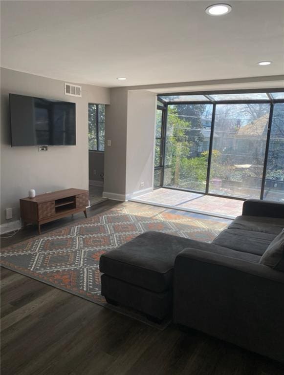 living room with visible vents, recessed lighting, baseboards, and wood finished floors