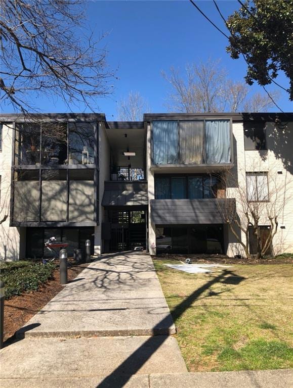 back of property with a lawn and a balcony