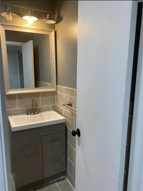 bathroom with tile walls, vanity, and tile patterned flooring