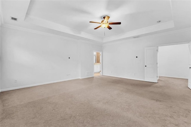 unfurnished room featuring crown molding, ceiling fan, a tray ceiling, and light carpet