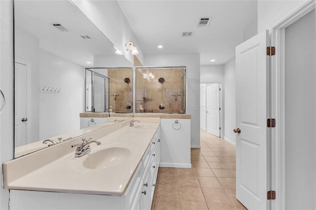 bathroom featuring tile patterned floors, a shower with door, and vanity