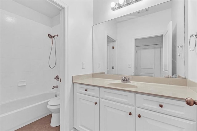 full bathroom featuring tile patterned flooring, vanity, tiled shower / bath combo, and toilet