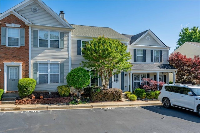 view of front of home featuring uncovered parking and a chimney