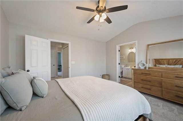 bedroom featuring vaulted ceiling, light colored carpet, connected bathroom, and ceiling fan