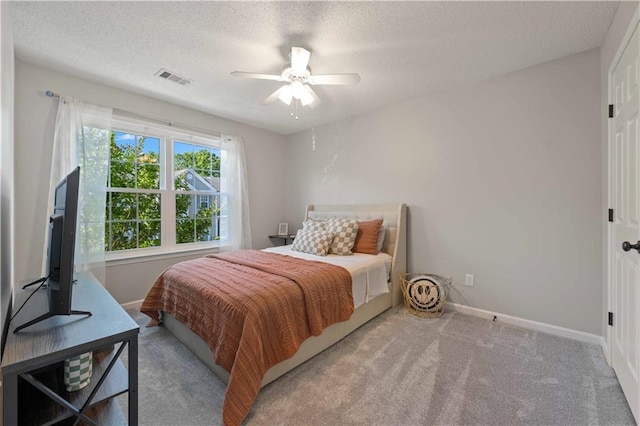 bedroom featuring a textured ceiling, baseboards, a ceiling fan, and carpet floors