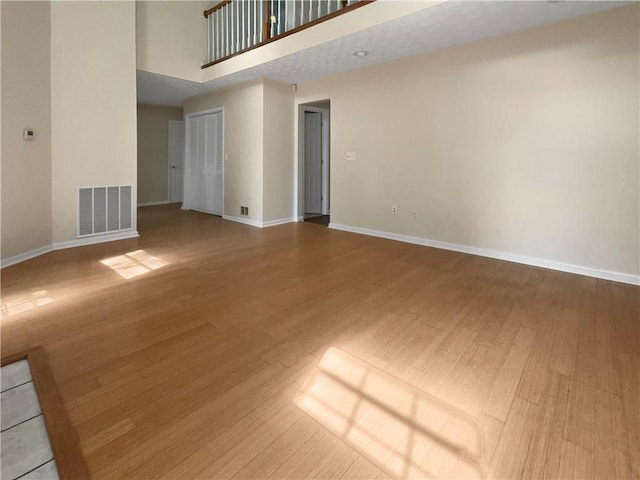 unfurnished room featuring hardwood / wood-style flooring and a high ceiling