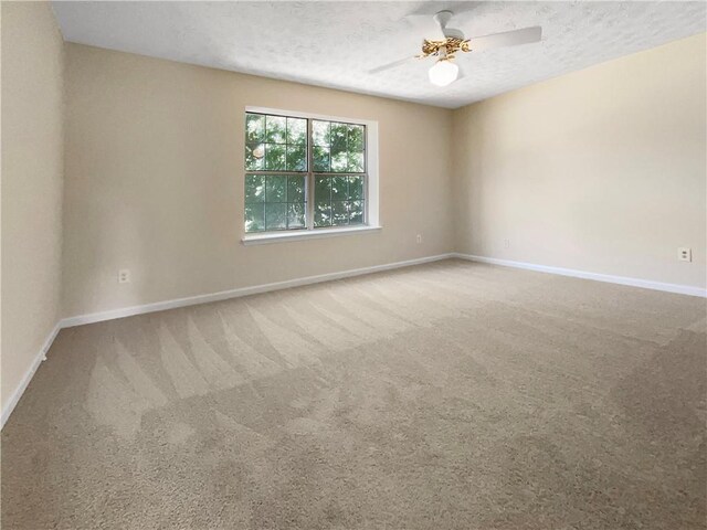 carpeted spare room featuring a textured ceiling and ceiling fan